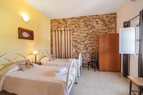 a hotel room with two beds and a brick wall at Casa dos Jotas in Martinlongo