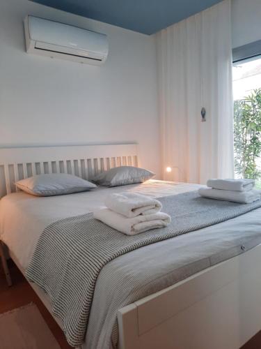 a bedroom with a bed with towels on it at Sitius 5B - NEW seaview apartment with rooftop terrace in historical centre Sitio da Nazaré in Nazaré