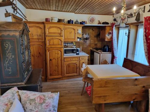 una cocina con armarios de madera y una mesa en una habitación en Waidach Home, en San Candido