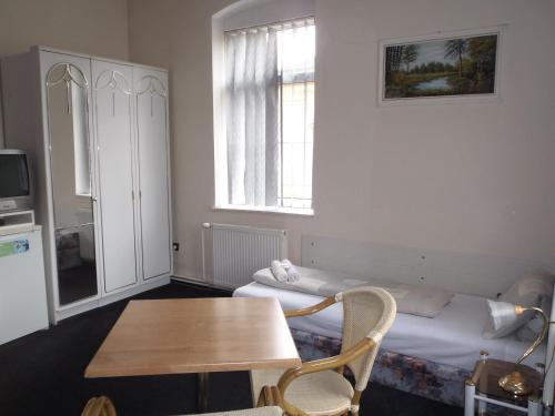a small room with two beds and a table at Pension a restaurace Kůlna in Chomutov