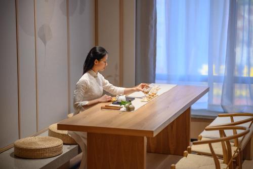 a woman sitting at a table in a room at Shenzhen ALLIN Space to time in Shenzhen