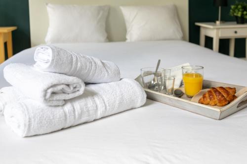 - un plateau de serviettes et un plateau de nourriture sur le lit dans l'établissement WS Montorgueil-Louvre, à Paris