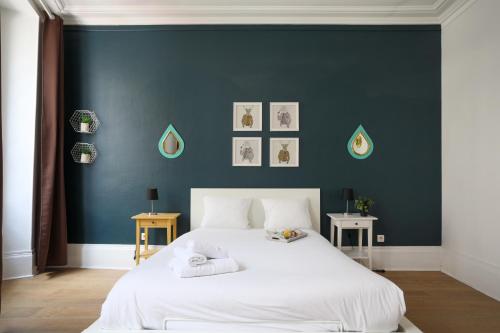 - une chambre avec un grand lit blanc et un mur bleu dans l'établissement WS Montorgueil-Louvre, à Paris