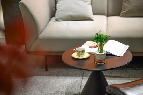 a table with two cups of coffee and a couch at Shenzhen ALLIN Space to time in Shenzhen