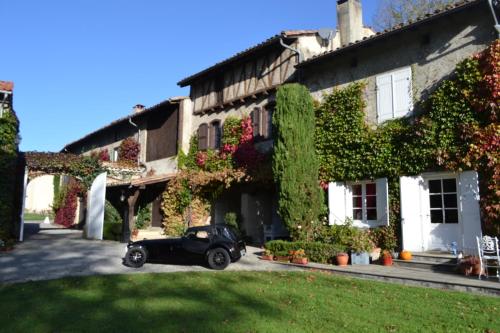 a black car parked in front of a house at Chambres d'Hôtes Domaine du Hameau Baylesse in Saint-Jean-dʼAigues-Vives