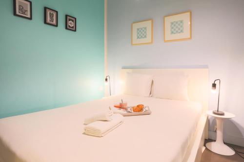 - un lit blanc avec une assiette de nourriture dans l'établissement WS Opéra-Folies Bergères, à Paris