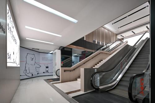 an escalator in a subway train with a mural on the wall at Shenzhen ALLIN Space to time in Shenzhen