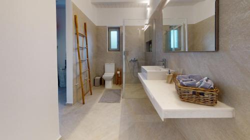 a bathroom with a sink and a toilet and a mirror at ONAR RESIDENCE PAROS in Chrissi Akti