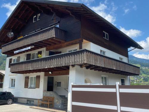 a house with a black roof and a fence at Ferienwohnung Alpennestchen Tschagguns in Tschagguns