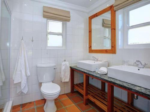 a bathroom with a toilet and a sink and a mirror at Varkenskraal Farm in De Rust