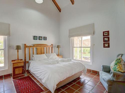 a bedroom with a large bed and a couch at Varkenskraal Farm in De Rust