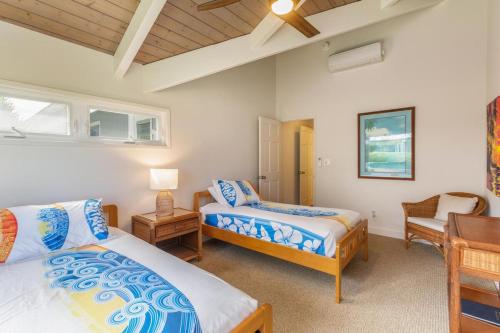 a bedroom with two beds and a desk and a chair at Makana Nui home in Hanalei