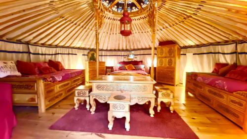 a bedroom with two beds and a table in a yurt at Eco Yourte Les Airelles in Saint-Anthème