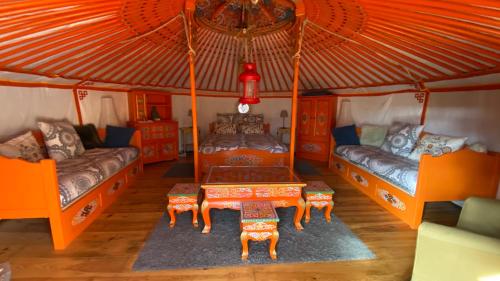 a room with two beds and a table in a yurt at Eco Yourte Les Airelles in Saint-Anthème