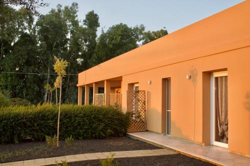 un edificio con fachada de naranja en MARIS APARTMENTS - Airport Shuttle en Alghero