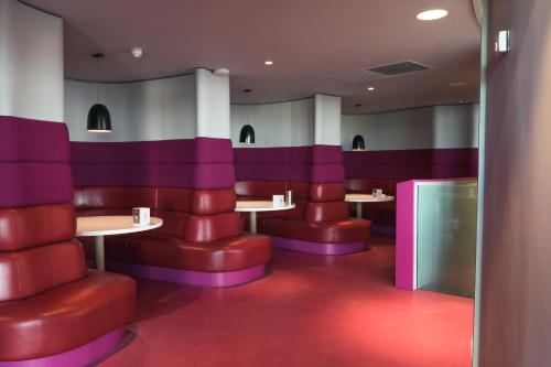a restaurant with red and purple booths and tables at The Midland in Morecambe