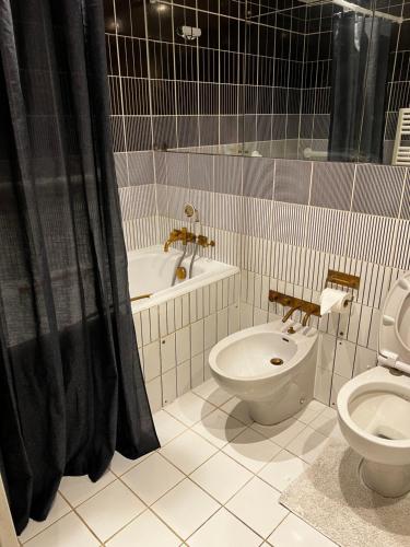 La salle de bains est pourvue de toilettes, d'un lavabo et d'une baignoire. dans l'établissement Mayfair Piccadilly - The Choice, à Londres