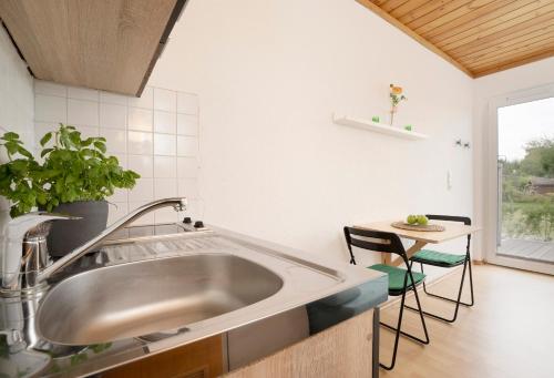 a kitchen with a sink and a table at Blankwasserweg 131 Lensterstrand Oase Bungalow 5 in Lenste