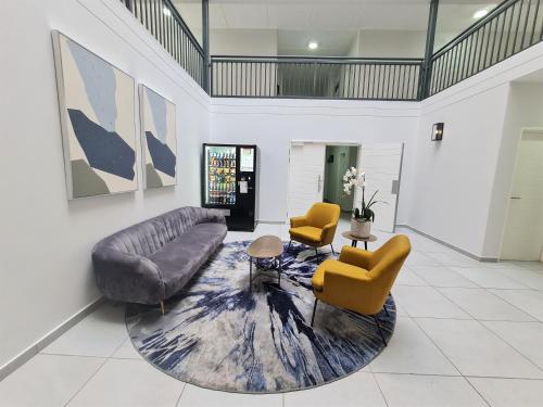 a living room with a couch and two chairs at MINT Express Melrose View in Johannesburg