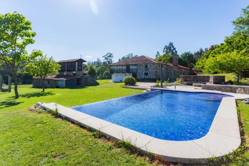 a swimming pool in the yard of a house at Casa da Ponte de Penas in Melide