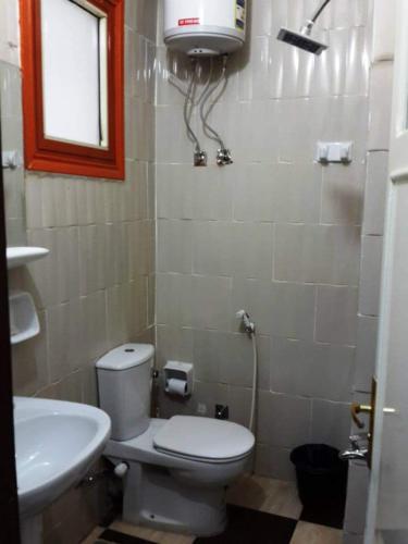 a small bathroom with a toilet and a sink at Dream Hotel in Qena