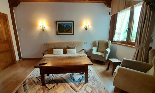 a room with a bed and a table and two chairs at Apartamentos El Haya in Cosgaya
