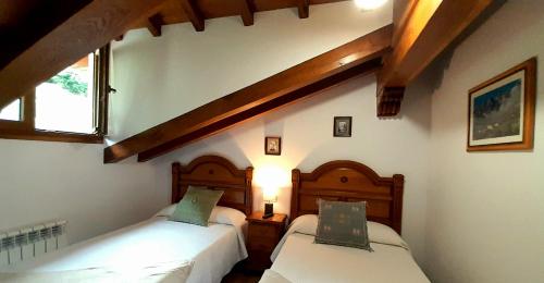 a bedroom with two beds in a room at Apartamentos El Haya in Cosgaya
