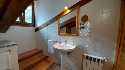 a bathroom with a sink and a mirror at Apartamentos El Haya in Cosgaya