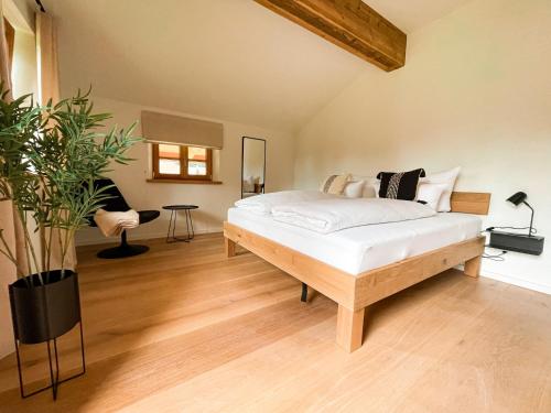 ein Schlafzimmer mit einem Bett und einer Topfpflanze in der Unterkunft Lichtdurchflutete Doppelhaushälfte in Kreuth in Kreuth