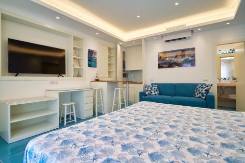 sypialnia z niebieskim łóżkiem i kuchnią w obiekcie ilTrucioloBBSuite w mieście Anacapri