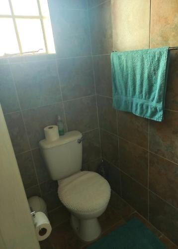 a bathroom with a toilet and a blue towel at B&B 464 on 22nd Ave in Pretoria