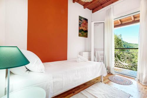 a bedroom with a bed and a large window at Elies Villa Corfu in Áno Garoúna