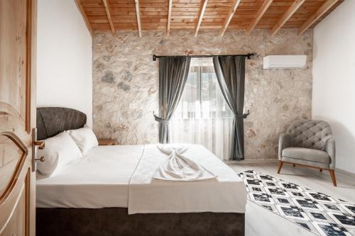 a bedroom with a bed and a chair and a window at VILLA TERAS in Adrasan