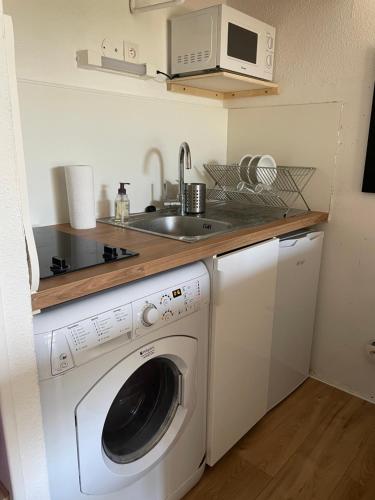 une cuisine avec une machine à laver et un évier dans l'établissement Appartement à Seignosse océan 2 chb et jardin, à Seignosse