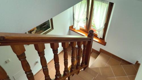 a staircase with a wooden railing and two windows at Apartamentos El Haya in Cosgaya