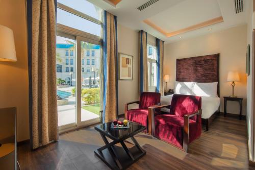 a hotel room with a bed and a chair and a table at Royal Maxim Palace Kempinski Cairo in Cairo