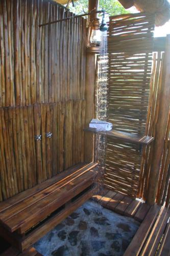 a wooden fence with a shower in a room at Parsons Hilltop Safari Camp in Balule Game Reserve