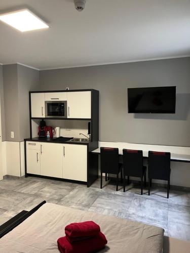 a room with a kitchen and a table with chairs at Garni Hotel Eastside in Magdeburg