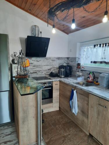 a kitchen with wooden cabinets and a counter top at Къща за гости Ози in Ovchartsi