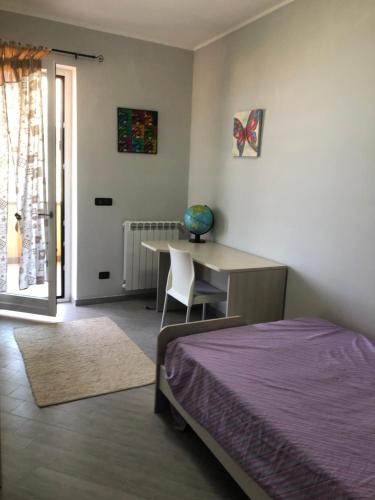 um quarto com uma cama, uma secretária e uma mesa em Panta Rhei em Villa San Giovanni