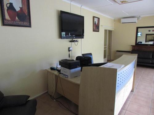 a office with a desk with a tv on the wall at Lalamnandzi1 in White River