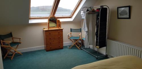 um quarto com uma cama, uma cómoda e uma janela em Beautiful 3 Bed Apartment with Balcony Sea View em Dunfanaghy