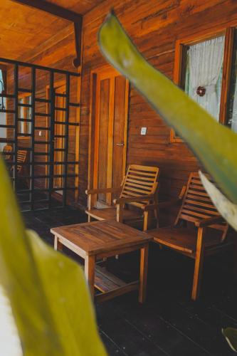 a room with two chairs and a table and a plant at Leaf Coco Bungalow in Gili Air