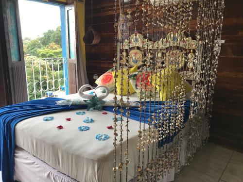 a bed in a room with a bed frame with beads at Pousada Alto Astral in Olinda