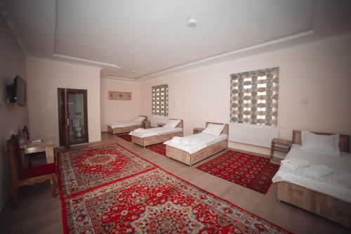 a living room with two couches and a rug at Oqilanur Guest House in Khiva