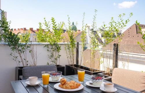 a table with two plates of food on a balcony at Abieshomes Serviced Apartments Schönbrunn in Vienna