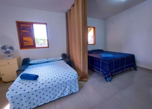 a bedroom with a blue bed and a window at Aconchego na Chapada in Lençóis