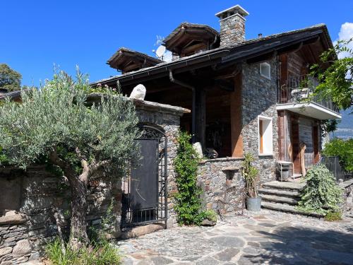 a stone house with a tree in front of it at Casa Unica- da Bruno in Colico