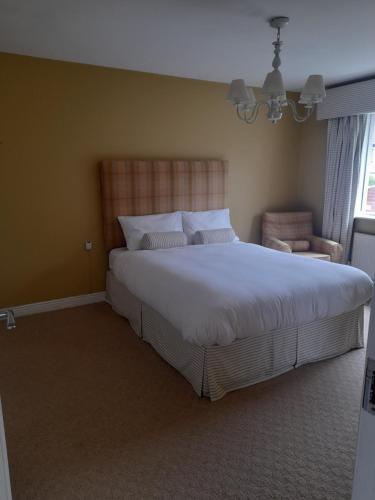 um quarto com uma cama grande e uma cadeira em 112 Roseberry Hill em Newbridge