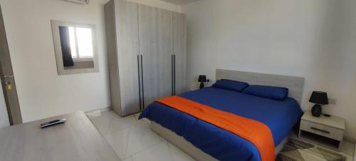 a bedroom with a bed with blue and orange sheets at Blu-M Central in Qormi